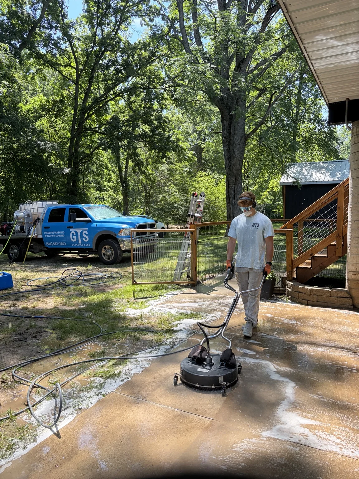 GTS cleaning a concrete patio with a surface cleaner