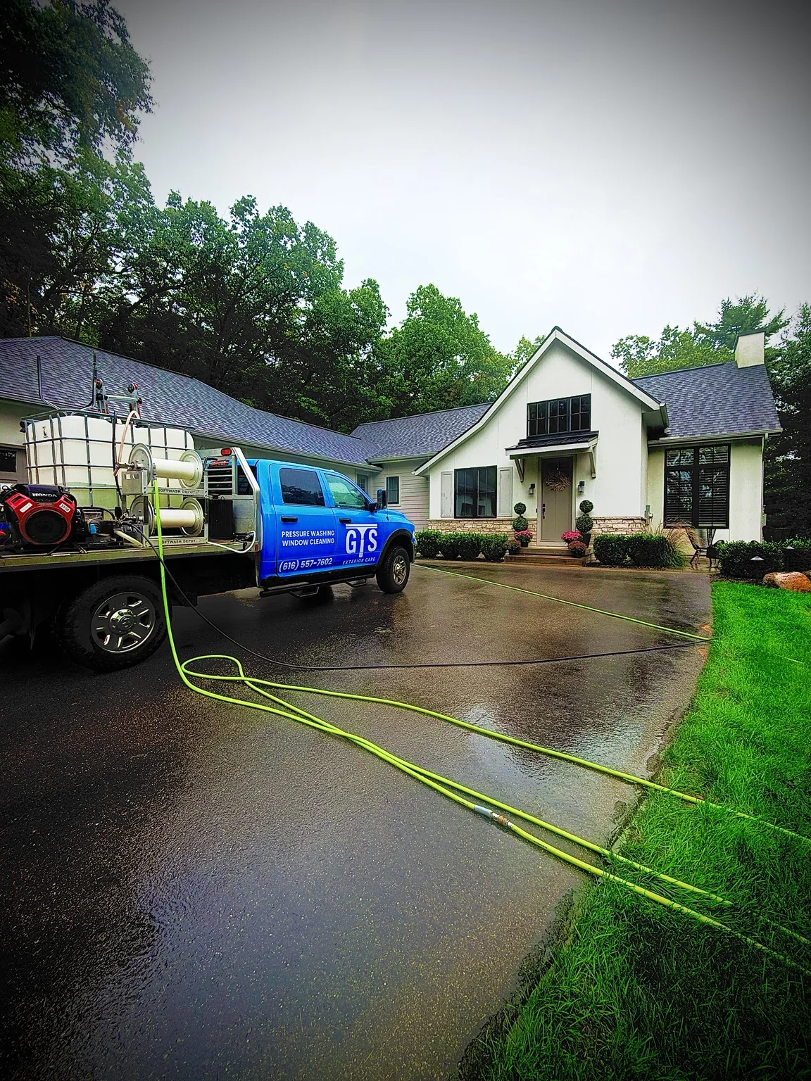 The blue GTS Exterior Care truck outside a white house