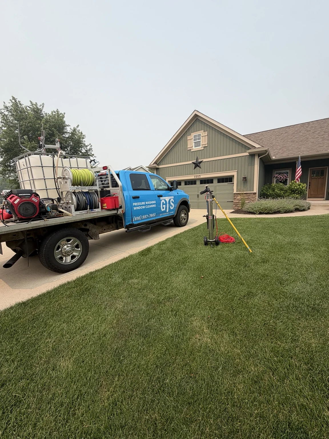 The blue GTS Exterior Care service truck and cleaning equipment outside a home